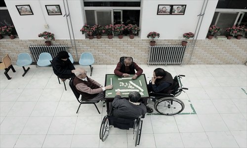 Four elderly men play mahjong at a nursing home in Beijing on March 22, 2012. Photo: CFP