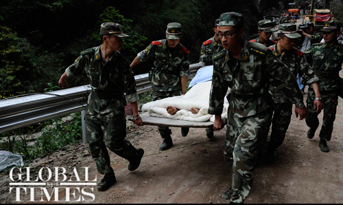 Police stretcher a person down a highway in Daxi, Tianquan county. Photo: Li Hao/GT