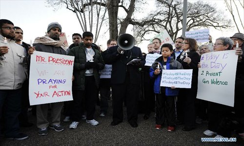Supporters of gun control legislation hold candles and placards during a rally to pay respect for the shooting victims in front of the White House in Washington, capital of the United States, Dec. 14, 2012, following a deadly shooting spree in an elementary school in Newtown, Connecticut, which took place earlier in the day. Photo: Xinhua
