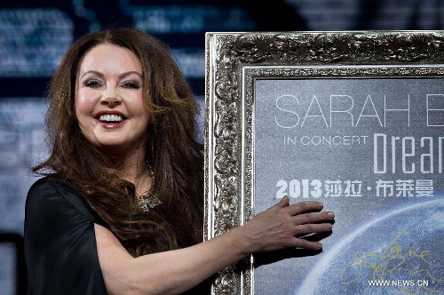 British singer Sarah Brightman points at her Chinese name on a poster of her China tour performance in Beijing, capital of China, Feb. 28, 2013. The British soprano will kick off her China tour Dreamchaser in June as she will perform in Beijing, Shanghai, Taipei, Guangzhou, Shenzhen and Nanning. (Xinhua/Zhang Yu) 