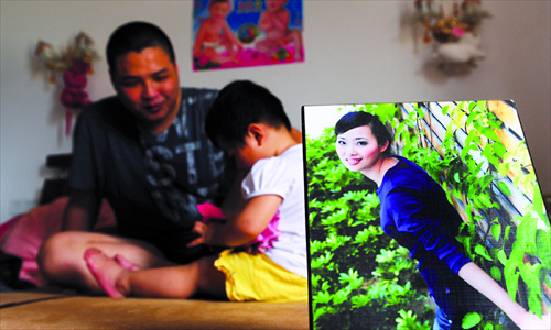 A young father, Xiaobin, displays a photo of his wife who left for the US to take care of her family business. Xiaobin and his daughter are planning to leave too. Photo: CFP