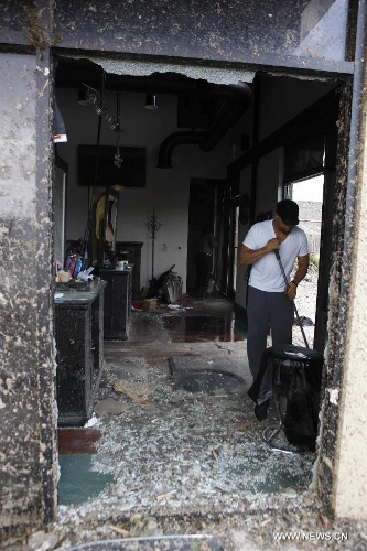 Volunteer Well cleans up a destroyed barber shop in Moore, Oklahoma, May 21, 2013, one day after a tornado moved through the area. A powerful tornado attacked on Monday afternoon the southern suburbs of the Oklahoma City, capital of the U.S. state of Oklahoma, killing at least 24 people, including 9 children. (Xinhua/Song Qiong)