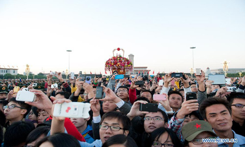 People watch the national flag raising ceremony at the Tian'anmen Square in Beijing, capital of China, October 1, 2012. Tens of thousands of people gathered at the Tian'anmen Square to watch the national flag raising ceremony at dawn on October 1, in celebration of the 63rd anniversary of the founding of the People's Republic of China. Photo: Xinhua