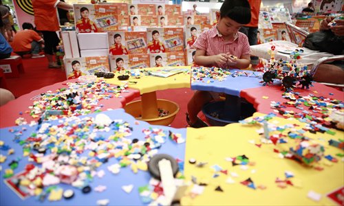 A boy plays with a jigsaw puzzle during the Kids Fun Expo at the China National Convention Center Thursday. The expo lasts until Sunday. Photo: Li Hao/GT