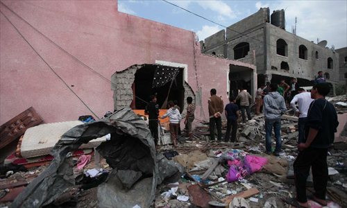 Palestinians stand on the rubble of their houses destroyed in an Israeli airstrike in the Jabaliya refugee camp, north of Gaza City, on Nov. 17, 2012. Since the violence surged last Wednesday, 48 people have been killed and more than 500 wounded. Photo: Xinhua