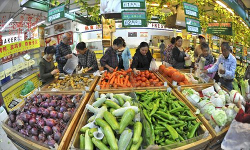 Consumers buy vegetable at a supermarket in Qionghai, south China's Hainan Province, December 9, 2012. China's consumer price index (CPI), a main gauge of inflation, grew 2 percent year on year in November, the National Bureau of Statistics announced Sunday. The inflation rate increased from a 33-month low of 1.7 percent in October as food prices increased. Photo: Xinhua
