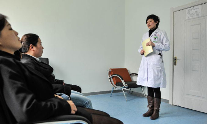 Yin Hongying, a hypnotist, treat patients during the hypnotherapy at a psychological hospital in Changchun, capital of northeast China's Jilin Province, April 25, 2013. After graduating from Yanbian Medical College, Yin had been working as a psychiatrist. Since 2007 she has been learning hypnotherapy. The past 6 years have witnessed over 300 patients' recovery thanks to her and hypnotherapy. 