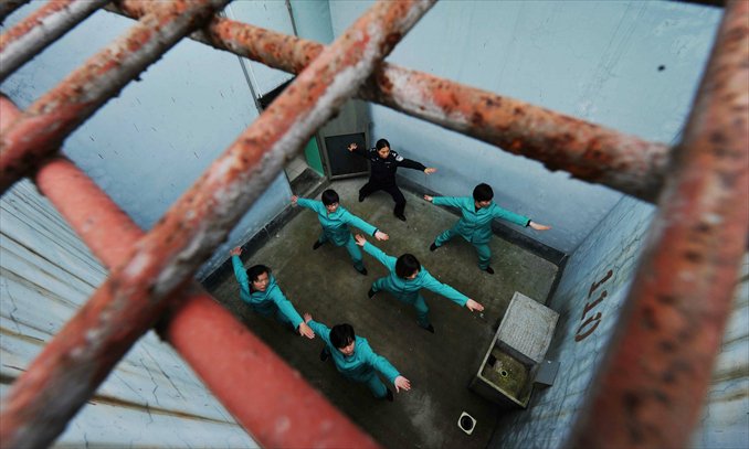 Inmates practice yoga in a yard under iron bars in a detention center in Wuyi, Zhejiang Province on April 11. Photo: CFP