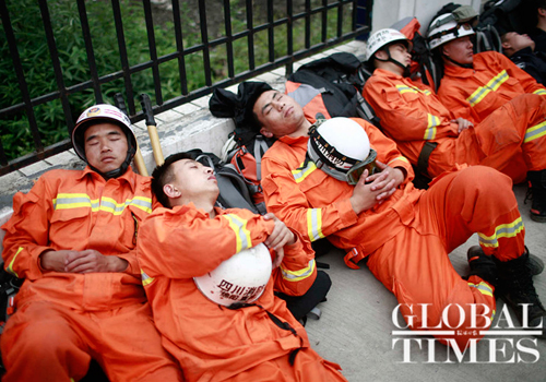 Local firemen rest on the side of a road in Lingguan, Baoxing county, Sichuan Province, on Sunday. Photo: Li Hao/GT