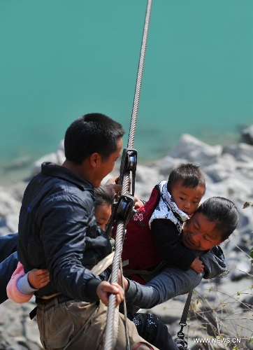 Residents from Shuangmidi Village cross the Nujiang River via a zip-line in Liuku County of Nujiang Lisu Autonomous Prefecture, southwest China's Yunnan Province, Feb. 2, 2013. More than 98 percent of Nujiang Lisu Autonomous Prefecture is occupied by mountains and valleys. The zip-lines have been quite popular transportation method along the Nujiang River since the ancient time. However, as transport conditions improve in recent years, a growing number of traditional zip-lines along the Nujiang River Valley have been dismantled or replaced by bridges. (Xinhua/Wang Changshan)  