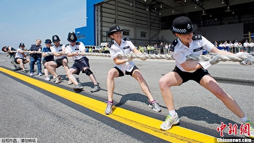 Policewomen pull on the rope connected to the Airbus A320 during the fourth annual Plane Pull' May 20, 2013 at JFK airport in New York. Teams of police officers from London's Metropolitan Police Service, city police officers, state police troopers and employees of British Airways PLC and JetBlue Airways Corp. race to move the Airbus A320 jet 100 feet in the fastest time, during the competition to benefit the charity Joining Against Cancer in Kids. (Photo Source: chinanews.com)