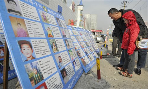 Local residents in Taiyuan, Shanxi Province, take a look at the posters placed by parents who are searching for their kidnapped loved ones. Photo: CFP
