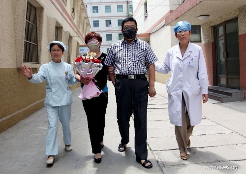 The H7N9 bird flu patient surnamed Zhang (2nd R) and his wife (3rd R) walk out of the Zaozhuang Municipal Hospital with medical staff members in Zaozhuang City, east China's Shandong Province, March 16, 2013. Zhang has recovered from the disease as the first H7N9 bird flu infection in Shandong Province. (Xinhua/Sun Zhongzhe)&nbsp; 