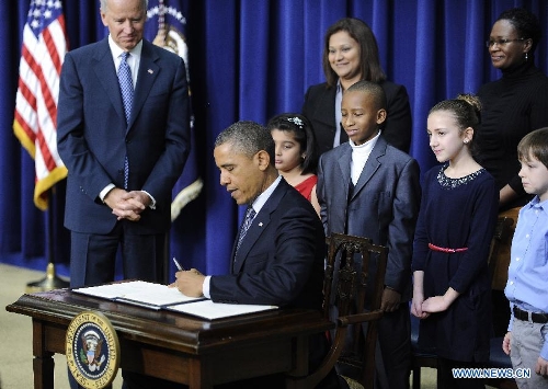 U.S. President Barack Obama signs executive orders on gun violence during an event at the White House in Washington D.C., capital of the United States, Jan. 16, 2013. Obama on Wednesday unveiled a sweeping and expansive package of gun violence reduction proposals, a month after the Sandy Hook Elementary School mass shooting killed 26 people including 20 schoolchildren. (Xinhua/Zhang Jun) 