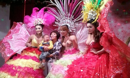 Tourists take photos with Thai ladyboys who were visiting Lushan, Jiangxi Province Sunday. Tourists could privately verify the gender of the  ladyboys if they paid 100 yuan ($15.90). Photo: CFP