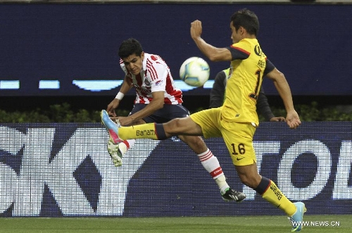 Chivas' Jesus Enrique Sanchez vies for the ball with Adrian Aldrete (R) of America during a Liga MX soccer match at the Omnilife Stadium in Zapopan, Mexico, on March 31, 2013. (Xinhua/StraffonImages) 