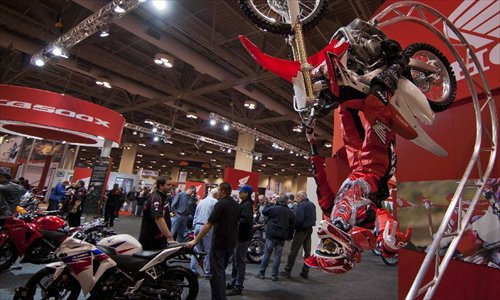 Visitors watch displayed motorcycles during the 2012 Toronto Motorcycle Show at the Metro Toronto Convention Centre in Toronto, Canada, December 8, 2012. The three-day event displays hundreds of new 2013 motorcycles, scooters from the world's top manufacturers from December 7 to 9 this year. Photo: Xinhua