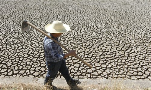 A farmer walks by a dried-up water reservoir in Shilin Yi Autonomous County, Kunming, Southwest China's Yunnan Province on Thursday. The drought-hit county hasn't seen rain since January 19, and has only recorded a rainfall of 6.9 millimeters since the beginning of this year, the lowest level in 49 years. More than 24,600 villagers have been affected by the drought, and over 8,200 livestock don't have sufficient drinking water. Photo: CFP