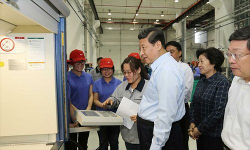 Chinese President Xi Jinping watches a trainee operating numerical control machine at the China Tianjin Public Vocational Training Center in north China's Tianjin Municipality. Xi Jinping made an inspection tour to Tianjin from May 14 to 15. Photo: Xinhua
