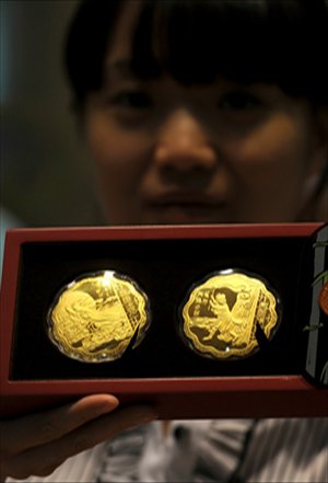  A jewelry store staff member shows off a pair of moon cakes made of gold in Nanjing, Jiangsu Province Tuesday. Photo: CFP