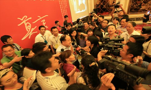 Fans and media crowd Mo Yan, winner of the 2012 Nobel Prize for Literature, at the 23rd national book trading fair in South China's Haikou, Hainan Province Friday. Mo was there to promote his new book about his experience accepting the Nobel Prize in Sweden. Photo: CFP