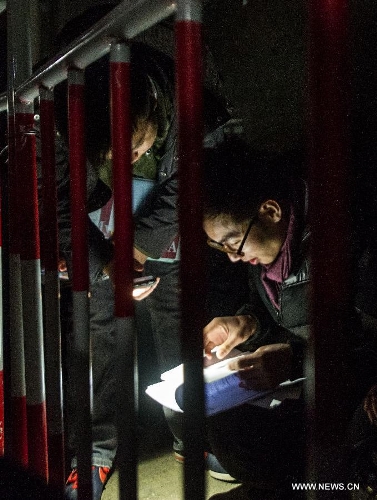 &nbsp;Housing agents look through clients' information by the light of cellphones at around 10 p.m. as they stand in a line for housing transaction next morning outside the Sixth Taxation Office of Chaoyang District Local Taxation Bureau in Beijing, capital of China, March 7, 2013. Secondhand housing transaction surges in Beijing these days as buyers and sellers are rushing to 