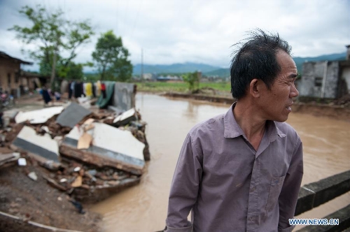 &nbsp;A villager stands beside his house destroyed by the rainstorm in Haoling Village of Jiaoling County, Meizhou City, south China's Guangdong Province, May 22, 2013. Meizhou City was hit by a rainstorm on May 19, which killed one people and destroyed 951 houses, leaving 180, 000 people affected in Jiaoling County. (Xinhua/Mao Siqian) 