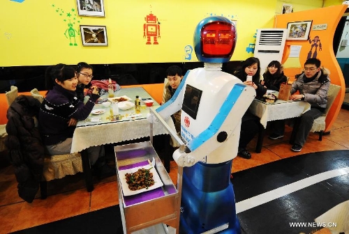 A robot serves dishes in a robot themed restaurant in Harbin, capital of northeast China's Heilongjiang Province, Jan. 18, 2013. Opened in June of 2012, the restaurant has gained fame by using a total of 20 robots to cook meals, deliver dishes and greet customers. (Xinhua/Wang Jianwei) 