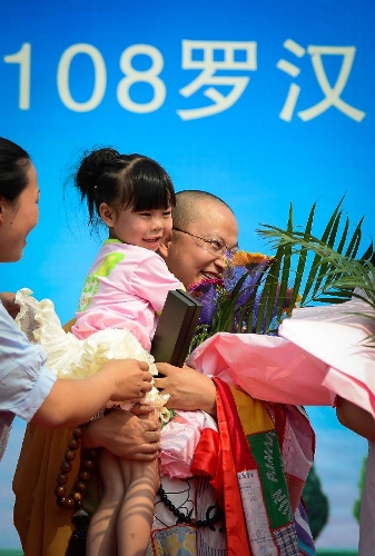 Tang Zhenwen, a 5-year-old girl, is carried by a monk at a birthday party at the Luohan Temple in Shifang City, southwest China's Sichuan Province, May 12, 2013. The birthday party was held for 108 children, who were born at the Luohan Temple five years ago after the devastating earthquake jolted Wenchuan County of Sichuan on May 12, 2008. The temple then was used as a temporary obstetrics hospital from May 13 to Aug. 7 in 2008 to deliver newborn babies. A total of 108 babies were born at the temple until the local maternal and child health care hospital reopened. (Xinhua/Jiang Hongjing) 