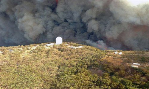 This aerial handout picture taken on January 13, 2013, provided by the Rural Fire Service of New South Wales shows smoke billowing from an out-of-control fire raging toward the Siding Spring Observatory. Photo: AFP/NSW Rural Fire Service