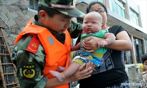 A soldier relocates residents to avoid risks posed by Typhoon Haikui in Wenzhou , east China's Zhejiang Province, August 7, 2012. Zhejiang Province relocated more than 1 million people threatened by Typhoon Haikui to safe places by Tuesday night. Typhoon Haikui landed in Hepu Town of the province's Xiangshan County early Aug. 8. Photo: Xinhua