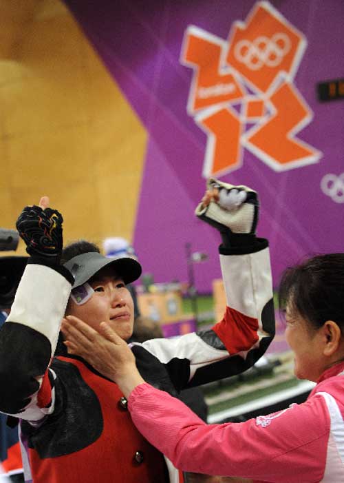 Yi Siling (L) of China reacts after winning in the Women's 10m Air Rifle Finals competition of the London 2012 Olympic Games at the Royal Artillery Barracks in London, Britain, on July 28, 2012. Yi Siling won gold medal with a total score of 502.9. Photo: Xinhua