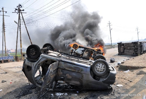Picture taken on Feb. 20, 2013 shows cars being burnt by protesters during a nationwide strike in Noida, India. Indian unions started a two-day strike Wednesday to protest high inflation, privatization of public sector and alleged anti-labor policies by the Congress-led government. (Xinhua/Stringer) 