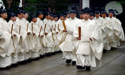 Shinto priests walk in line to the main shrine for a rite during the first day of the three-day annual spring festival at the Yasukuni Shrine in Tokyo on Sunday. Deputy Prime Minister Taro Aso on Sunday visited the shrine, which counts Japanese war criminals from World War II among those it honors. Photo: AFP