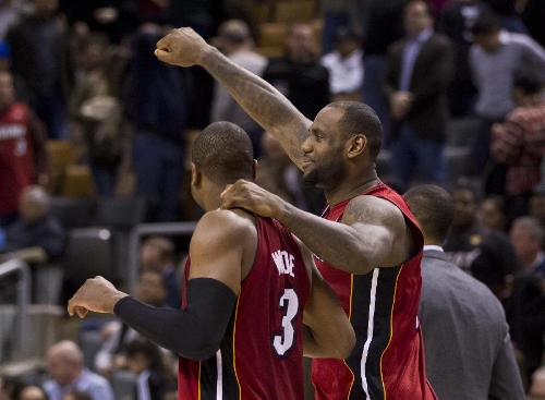 LeBron James (R) of Miami Heat celebrates victory with teammate Dwyane Wade during the NBA game against Toronto Raptors at Air Canada Centre in Toronto, Canada, March 17, 2013. Heat won 108-91. (Xinhua/Zou Zheng) 