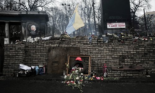 Flowers are left at a makeshift memorial at barricades near the Dynamo Kiev stadium in central Kiev on Tuesday. Photo: AFP