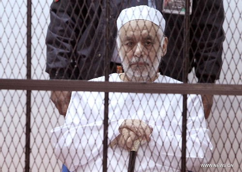 Former Libyan Prime Minister Baghdadi al-Mahmoudi sits in a cage during his trial at a court in Tripoli, capital of Libya, on Jan. 14, 2013. The trial of former Prime Minister Baghdadi al-Mahmoudi started here on Monday. Mahmoudi, who served as the last prime minister in former leader Muammar Gaddafi's administration from 2006 to 2011, fled to Tunisia in September 2011 after the armed rebels seized the Libyan capital of Tripoli during the unrest. (Xinhua/Hamza Turkia) 