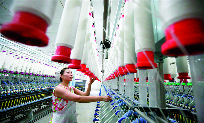 A woman works at a textile factory in Huaibei, Anhui Province on Friday. Chinese exports have suffered from slumping overseas demand. Photo: IC