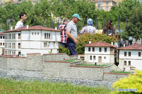 Visitors walk pass the miniature of traditional Turkish houses in the Miniature park in Istanbul, Turkey, on May 11, 2013. The Miniaturk park is the first miniature park in Istanbul and has welcomed 6.5 million visitors over the past 10 years. (Xinhua/Lu Zhe) 