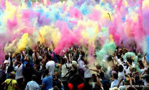 People throw colorful powder during the Holi Festival of Colours, at the Reiterstadion in Berlin, Germany, May 11, 2013. The celebration of Holi Festival of Colours has been launched in Germany since 2012 as a new carnival of German people marking the advent of spring. (Xinhua/Pan Xu) 