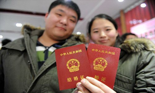 A couple show their marriage certificates at the marriage registration office in Zhengzhou, capital of Central China's Henan Province, January 4, 2013. Quite a number of couples flocked to tie the knot on January 4, 2013, or 2013/1/4, which sounds like 