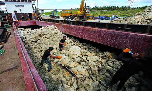 Workers offload clams from a fishing boat that is among the 12 boats intercepted by Philippine naval forces in April. Photo: Cai Xianmin/GT