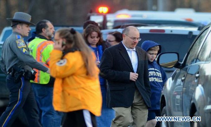 Escorted by his family member, a child (right) leaves the Sandy Hook Elementary School after the fatal school shooting in Newtown, Connecticut, the United States, Dec. 14, 2012. Photo: Xinhua
