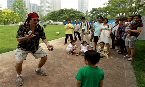 Rhett Farber, one of the organizers of the city's first World Juggling Day, shows some young fans ball skills with a difference. Photo: Yang Hui/GT