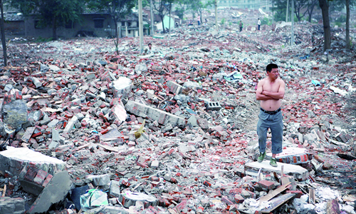 A resident stands on the ruins of the houses that were allegedly forcibly demolished Monday. Photo: Li Hao/GT