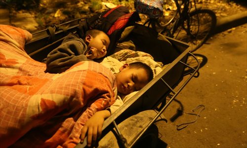 Two sons of local resident He Jian sleep in a tricycle cart along the roadside of the Sichuan-Tibet Highway. A 7.0-magnitude earthquake hit Lushan county on the morning of April 20. Longmen, Baosheng and Taiping townships were the worst hit areas. Victims spent their first night after the quake in temporary tents along the roadside. Photo: Xing Guangli/Xinhua