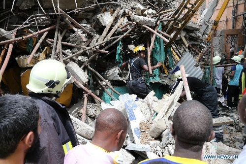 Rescuers search for survivors at the building collapse site in downtown Dar es Salaam, Tanzania, March 29, 2013. A 16-storey building on Friday morning collapsed in Dar es Salaam, with more than 60 people got trapped in the debris. No casualties have been reported as of noon local time. (Xinhua/Zhang Ping)