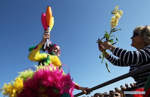 A performer (L) takes part in the flowers parade during the 129th annual Nice Carnival parade, in Nice, southern France, March 2, 2013. (Xinhua/Gao Jing)