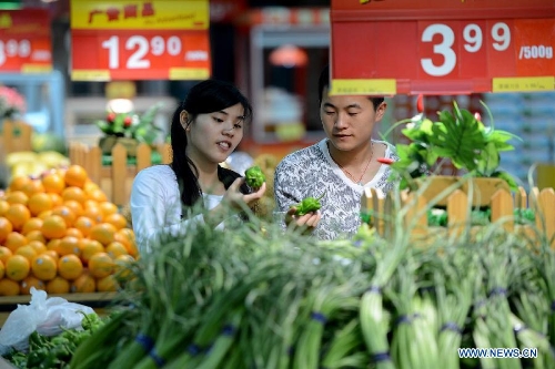 Consumers select vegetable at a supermarket in Hefei, capital of east China's Anhui Province, May 9, 2013. China's consumer price index (CPI), a main gauge of inflation, grew 2.4 percent year on year in April, up from 2.1 percent in March, the National Bureau of Statistics (NBS) said Thursday. The NBS attributed the gain mainly to an unusual increase in vegetable prices during that month as low temperatures and scarce rainfalls disrupted supplies. (Xinhua/Zhang Duan) 