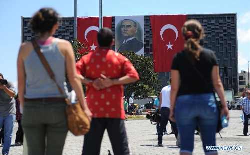 Protestors stand silently in front of Ataturk culture centre near the Taksim Square in Istanbul, Turkey, on June 18, 2013. Hundreds of people stood silently from morning to evening on Tuesday here to protest against the government. Nationwide protests began when an environmentalists' rally aiming to preserve Gezi Park adjacent to Taksim Square in Istanbul met fierce police crackdown, which triggered a wave of fiery opposition against the government's policies. (Xinhua/Lu Zhe) 